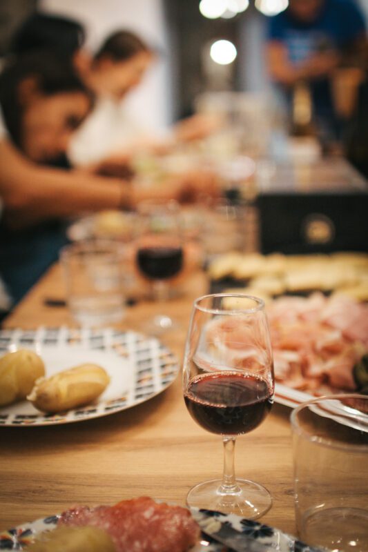 a glass of wine on a table in France with raclette